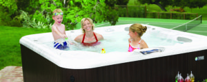 Mother and kids playing outdoors in hot tub