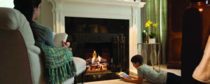 Young boy laying by fireplace reading
