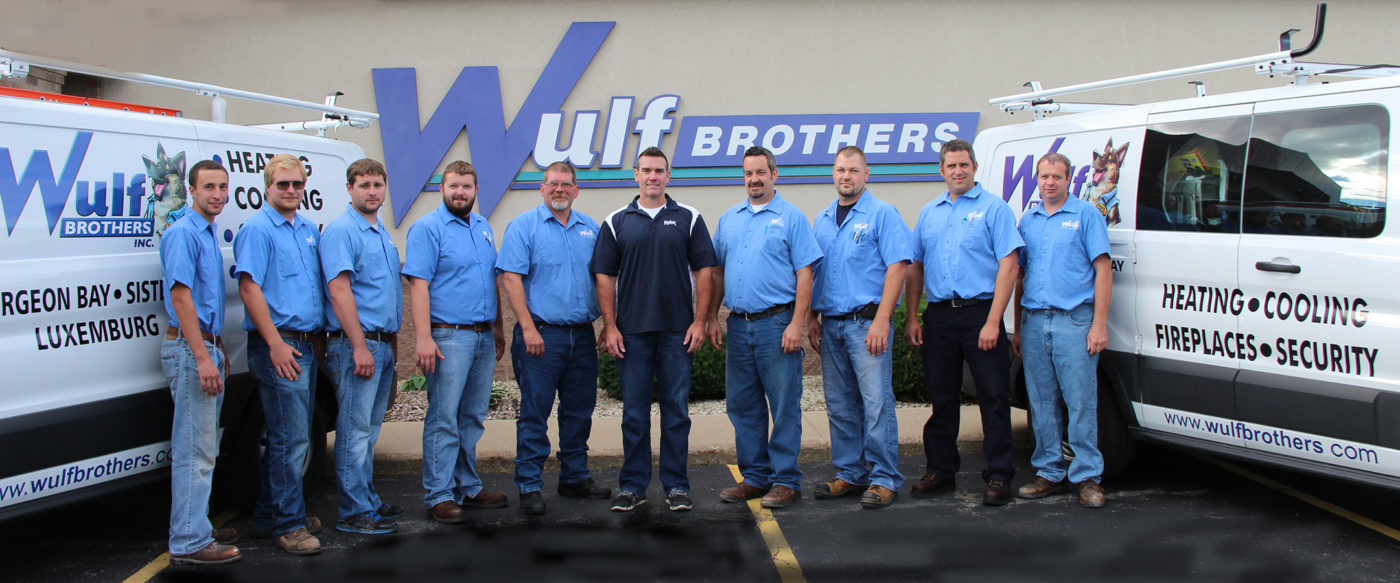 Wulf Brothers team standing in front of building with trucks